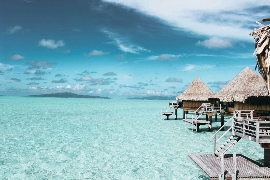 Overwater bungalows on a crystal-clear turquoise sea in French Polynesia.