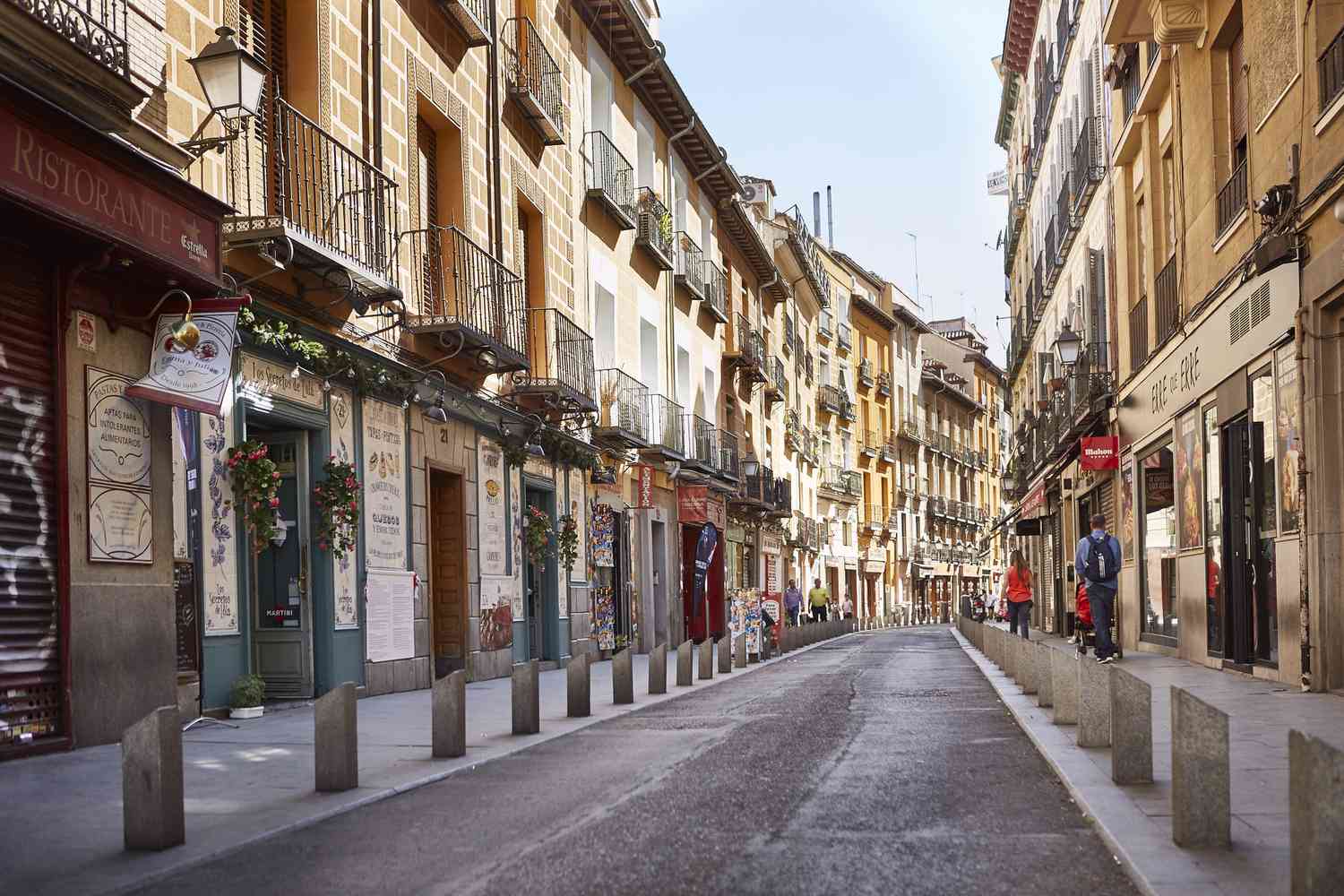 A series of buildings in a row, featuring diverse designs and colors under a bright blue sky.