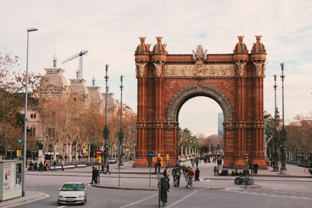 A large archway stands prominently in the center of a bustling city street, surrounded by buildings and pedestrians.