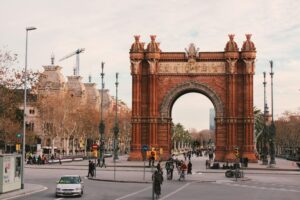 A large archway stands prominently in the center of a bustling city street, surrounded by buildings and pedestrians.