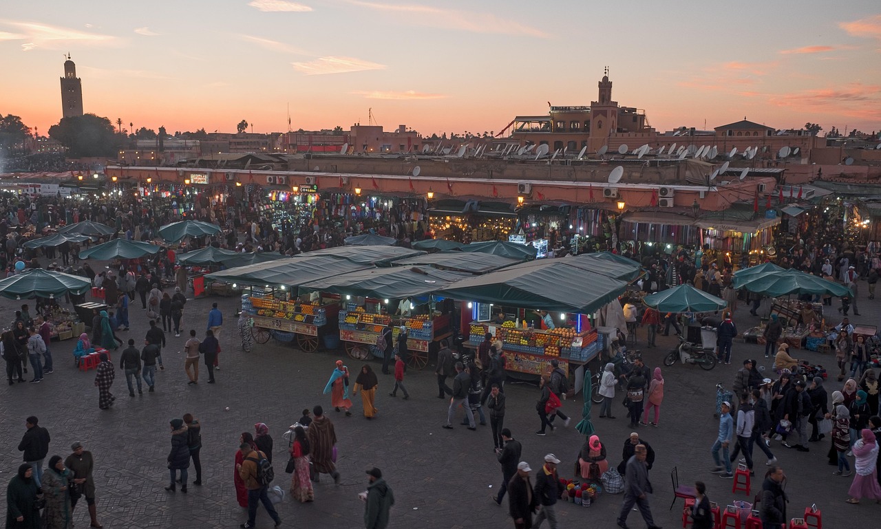 Sunset over Marrakesh, Morocco, casting warm hues across the sky and illuminating the city's silhouette.