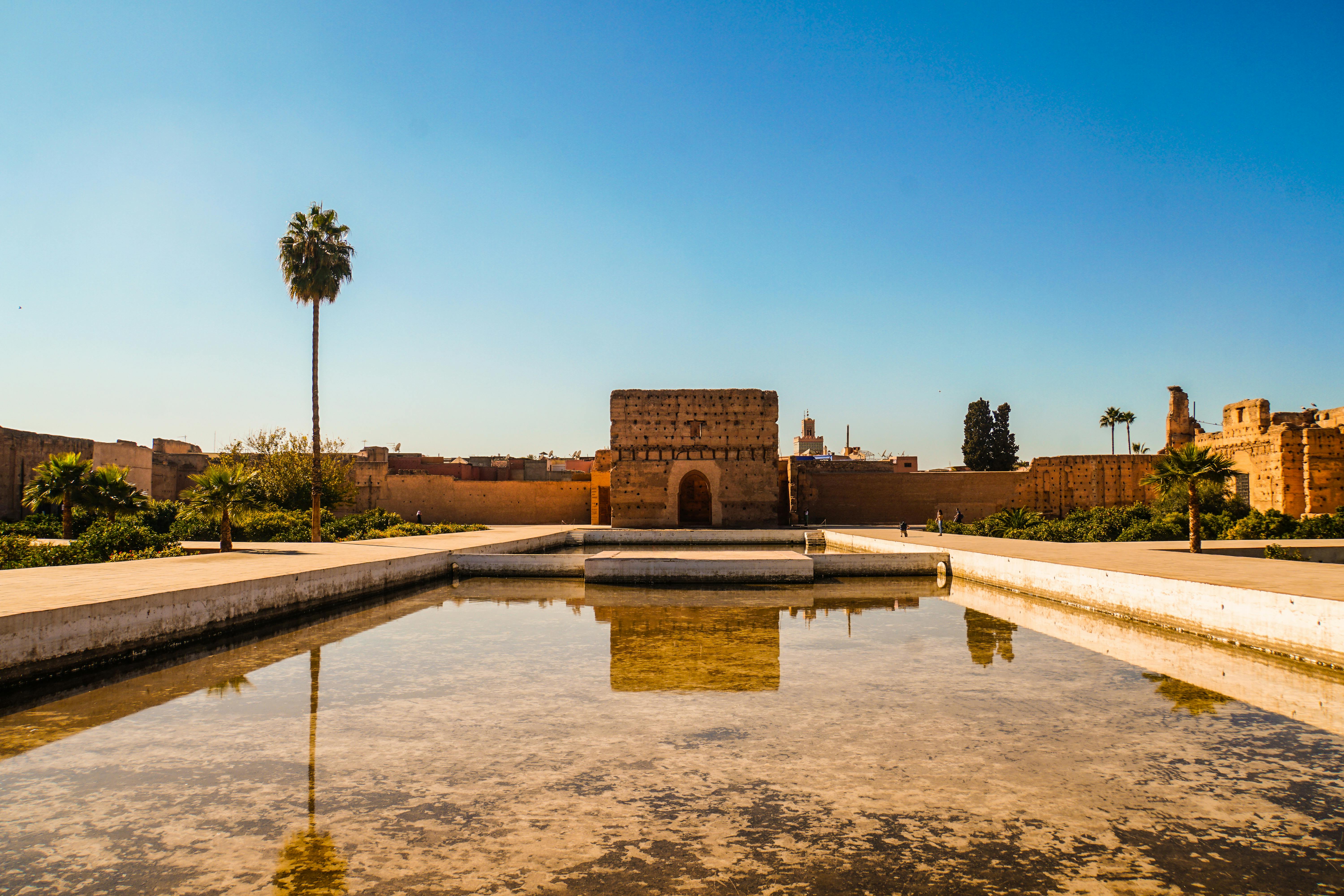 The serene courtyard of the Alhambra Palace in Marrakech, Morocco, featuring intricate tile work and lush greenery.