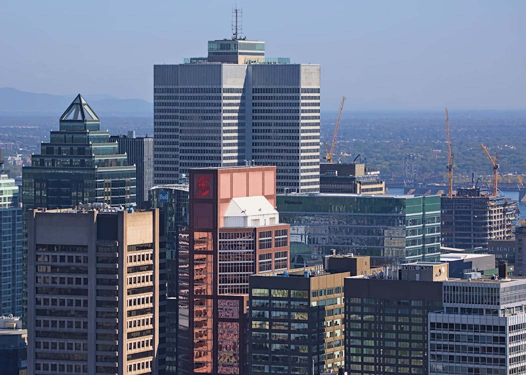 Aerial view of Montreal downtown skyline with green spaces and the St. Lawrence River