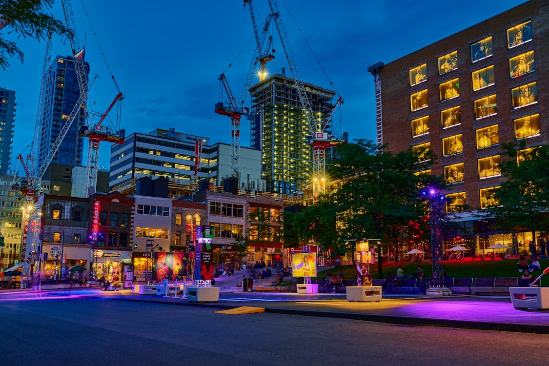 Dynamic nighttime scene of downtown Montreal with illuminated skyscrapers reflected in wet streets