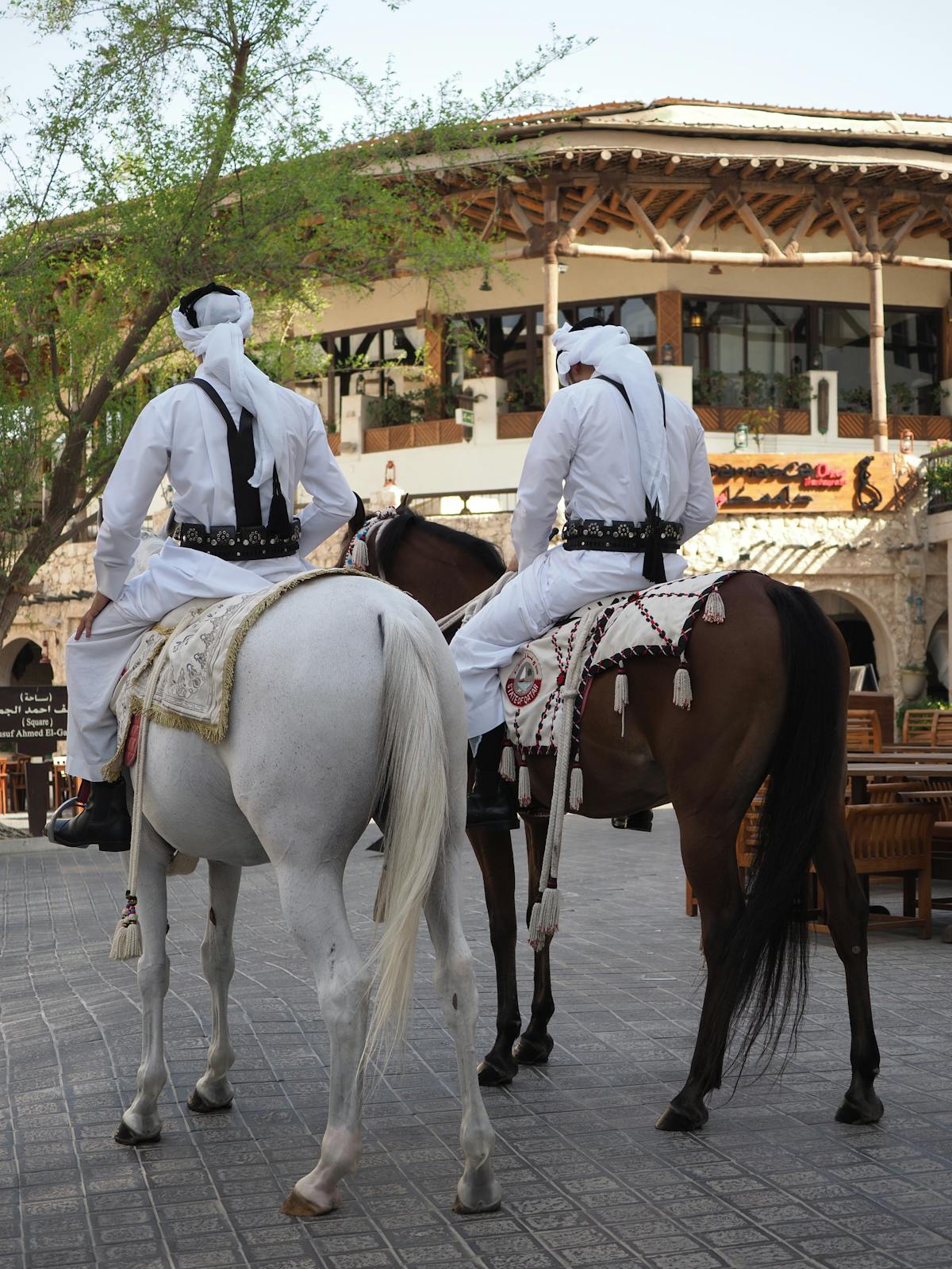 Traditional riders in Souq Waqif old market Doha Qatar heritage