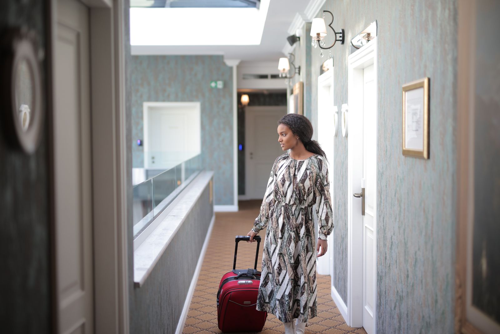 Traveler arriving at a hotel with a suitcase, booking details saved in the Stamped app
