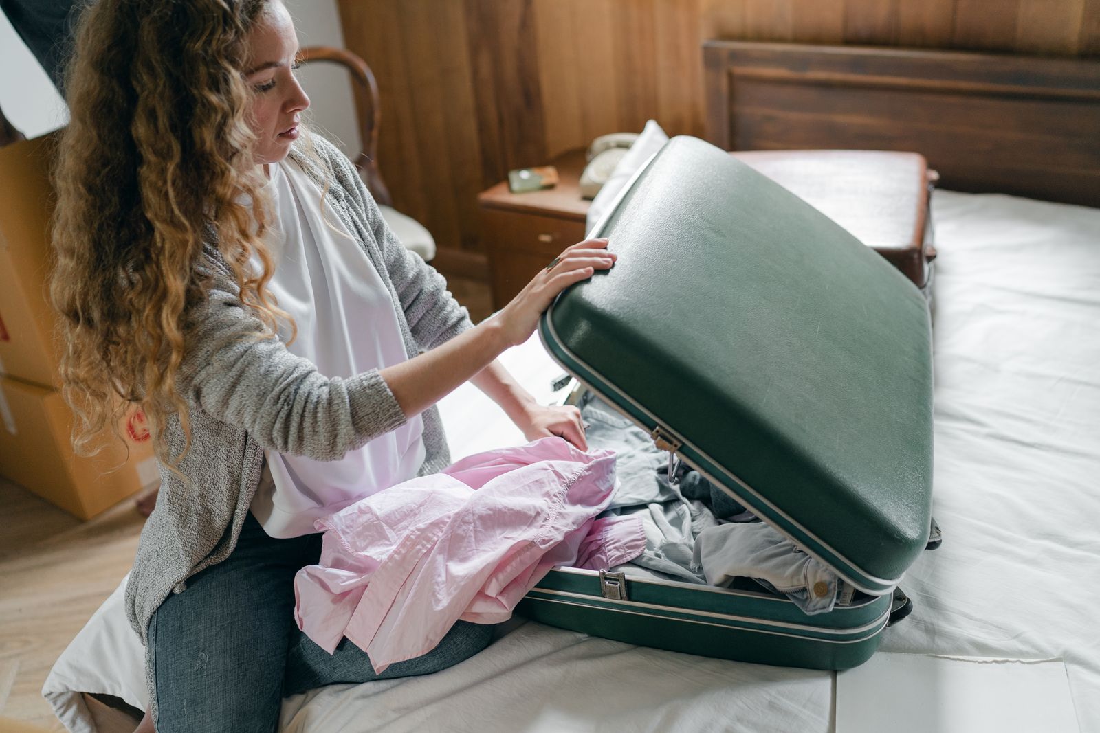 Traveler packing a suitcase before a trip, trip ready with the Stamped travel planner app
