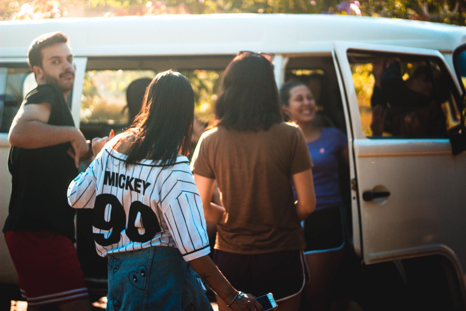 Friends loading into a van for a group road trip coordinated with the Stamped travel planner app