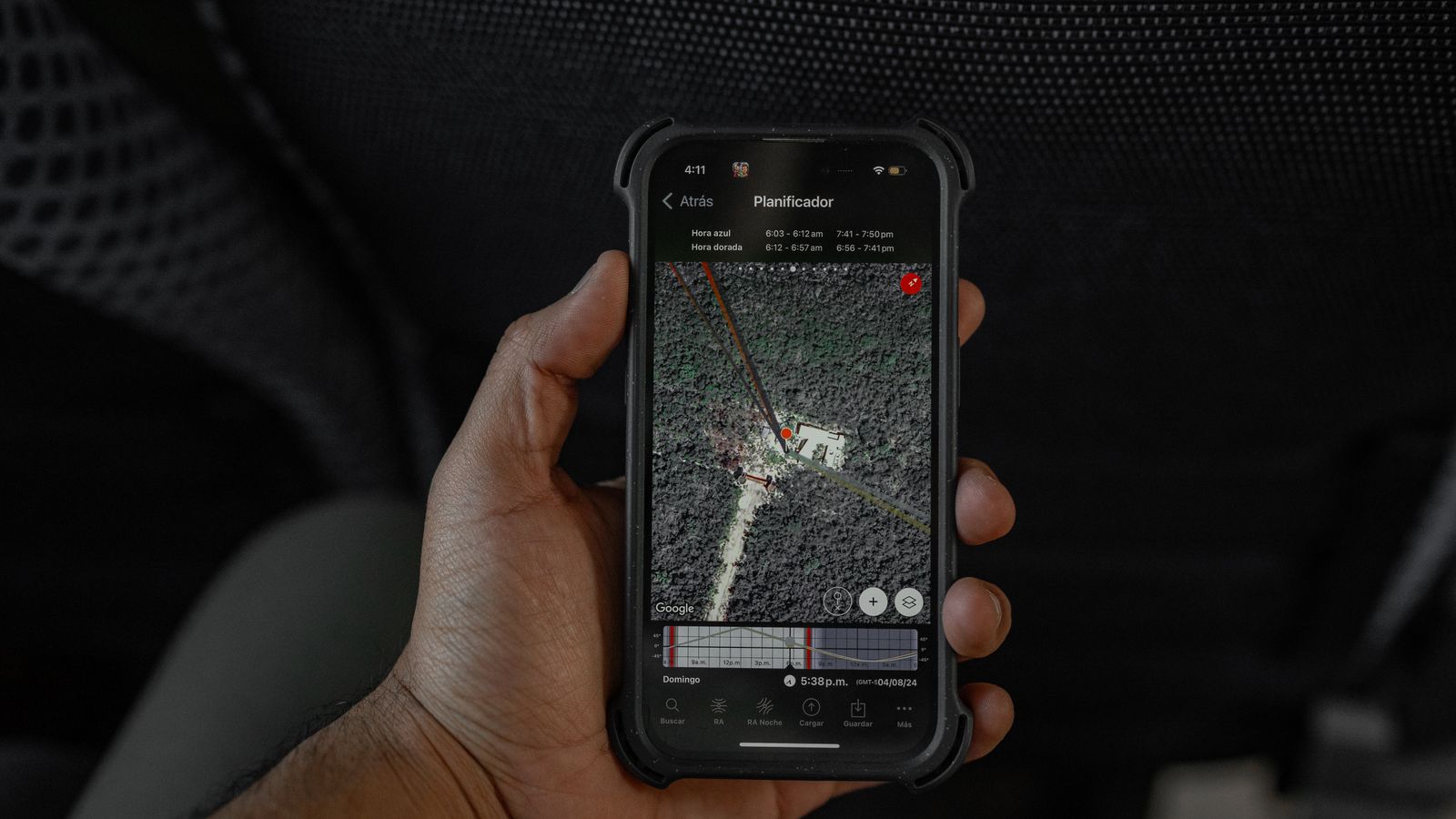 Hand holding a smartphone showing a GPS map while travelling