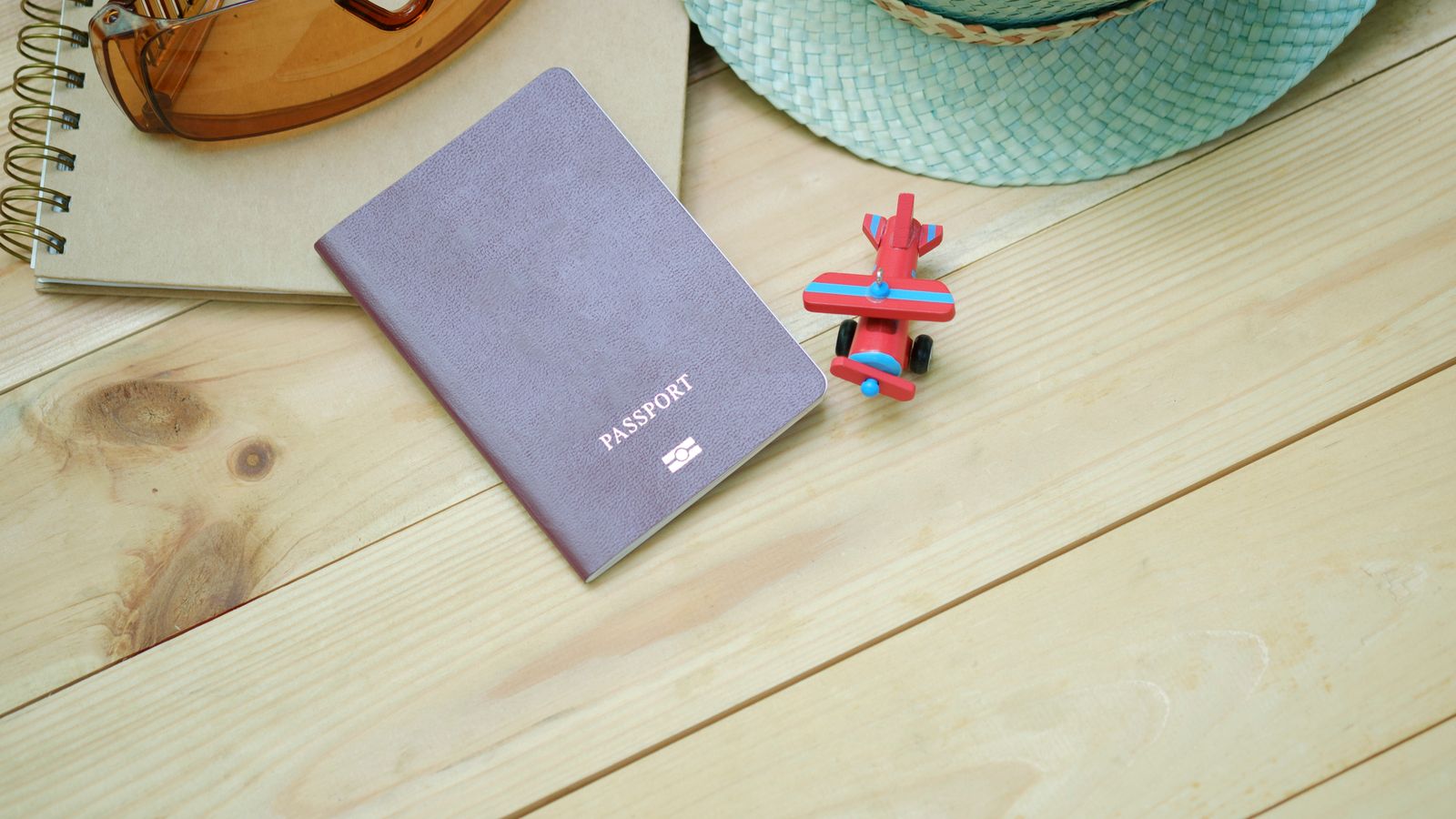 Open map and notebook on a wooden desk while planning a trip itinerary by hand