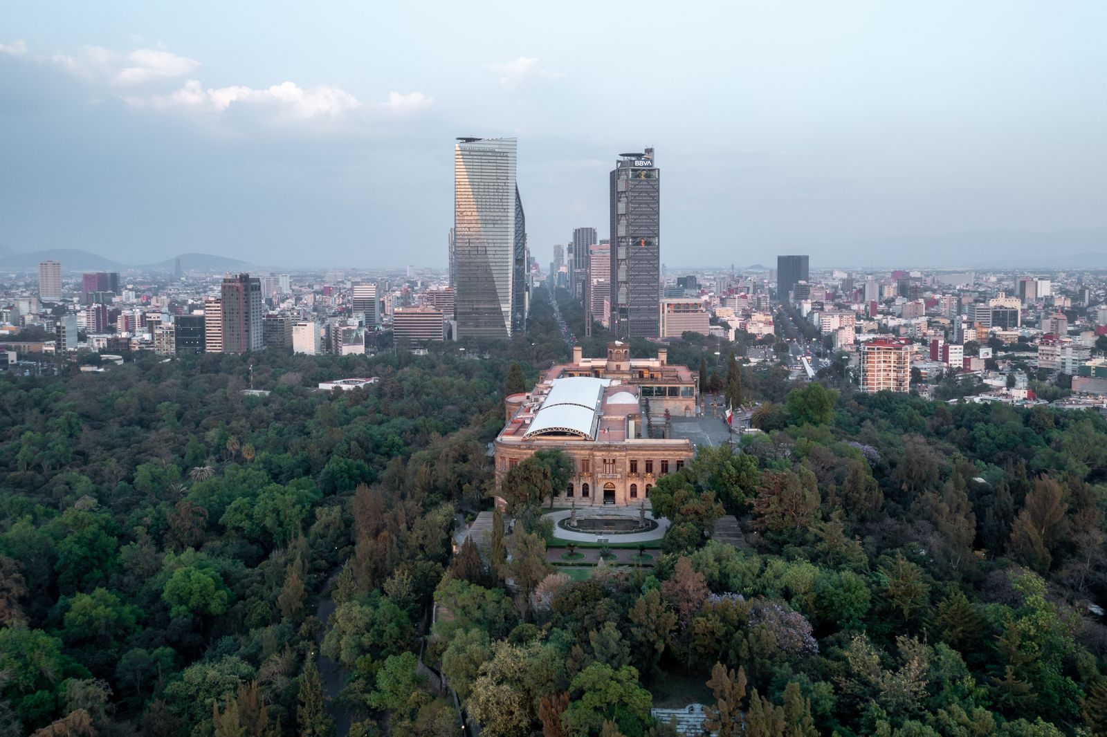 Chapultepec Castle rising above the trees of Bosque de Chapultepec with the Mexico City skyline behind it