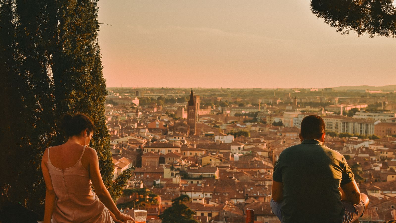 Couple relaxing at a sunset viewpoint over Verona Italy at the end of a well planned travel day